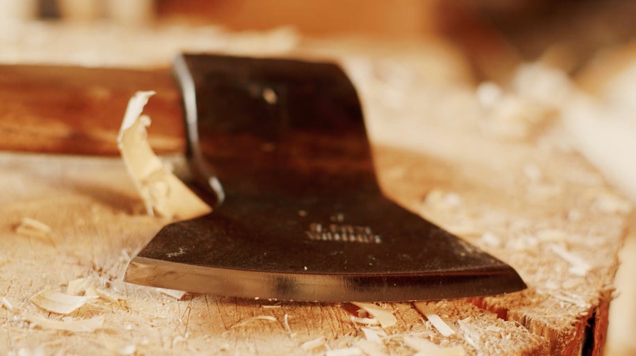 Sekera s drevenou rukoväťou na drevenom bloku s drevenými štiepkami