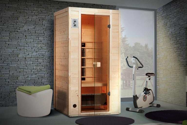 Drevená sauna so sklenenými dverami a ovládacím panelom vedľa rotopedu