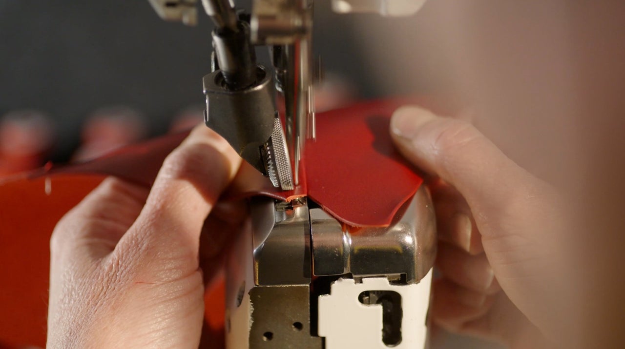 Detailný záber osoby pracujúcej so šijacím strojom