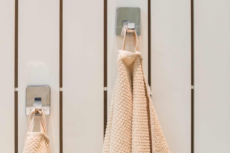 Uteráky visia na háčikoch na uteráky v kúpeľni.