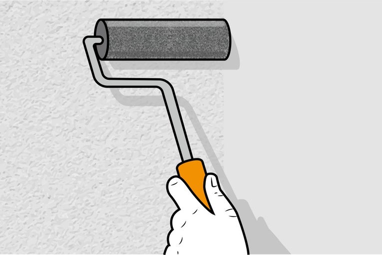 Ruka drží valček na maľovanie na stene.