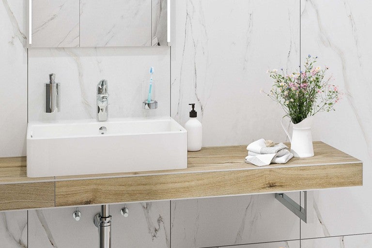 Moderná kúpeľňa s umývadlom, vodovodnou batériou a doplnkami na drevenej poličke