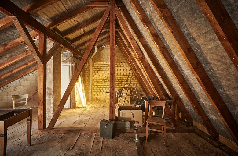 Podkrovie s drevenými trámami, murivom a rebríkom