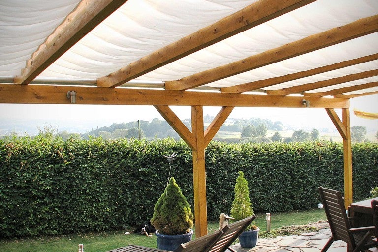 Drevená pergola so slnečnou plachtou v záhrade