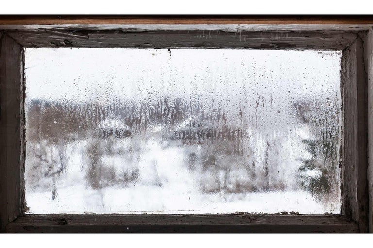 Pohľad zo starého okna na zasneženú krajinu