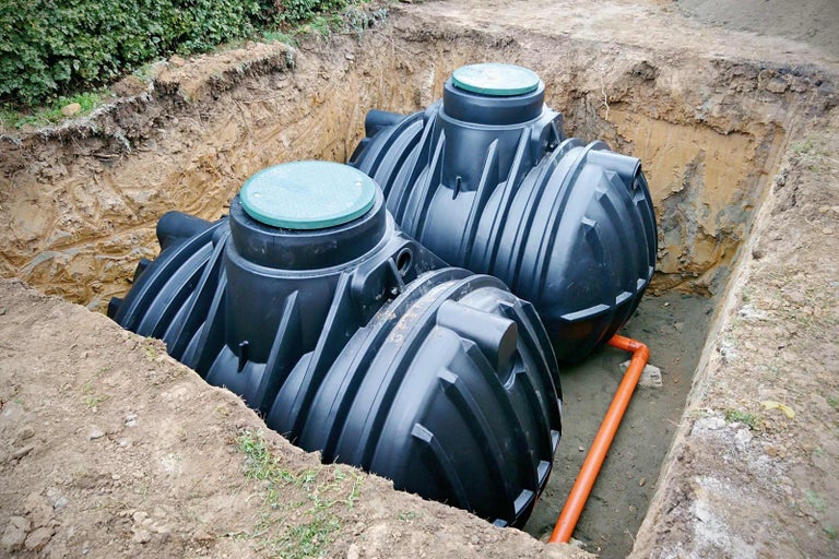 Zakopaná čistička odpadových vôd s plastovými nádržami a oranžovou rúrou