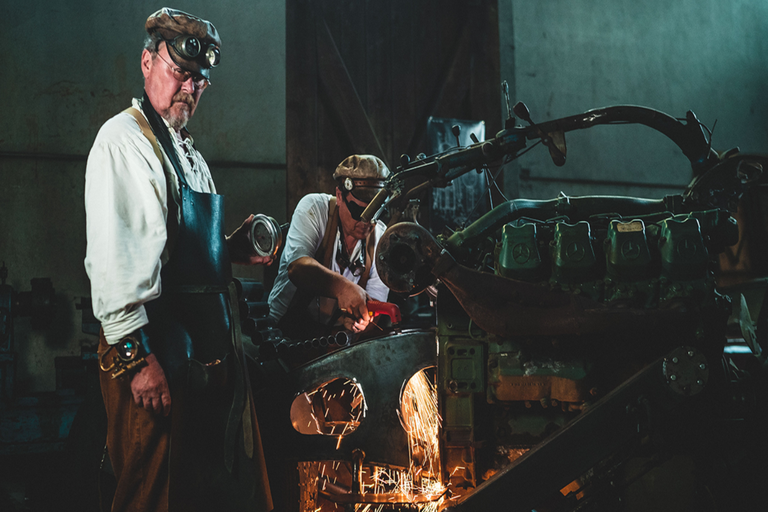 Dvaja remeselníci pracujú s rezačkou na stroji v dielni.