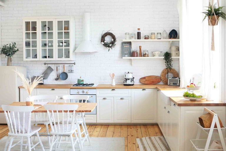 Svetlá kuchyňa vo vidieckom štýle s dreveným stolom a bielymi stoličkami
