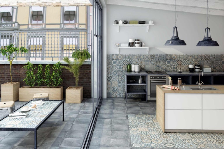 Svetlá, priestranná kuchyňa s dlažbou, kuchynským ostrovom a vonkajším jedálenským priestorom.