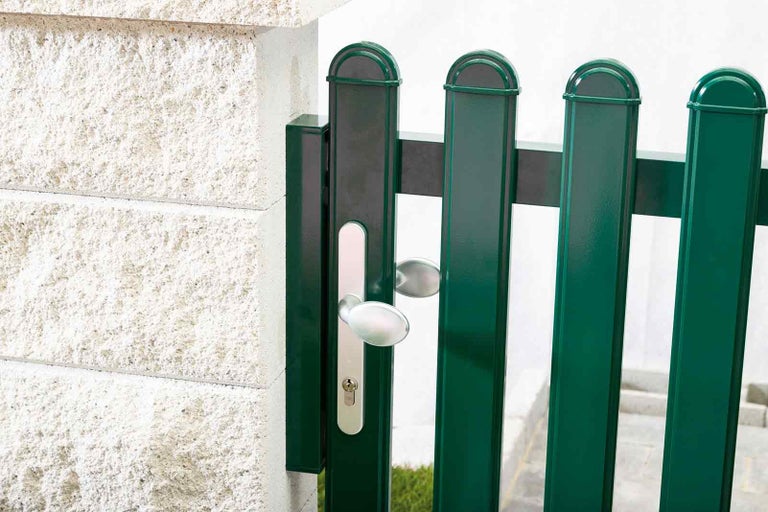 Detailný pohľad na zelenú záhradnú bránku so striebornou kľučkou