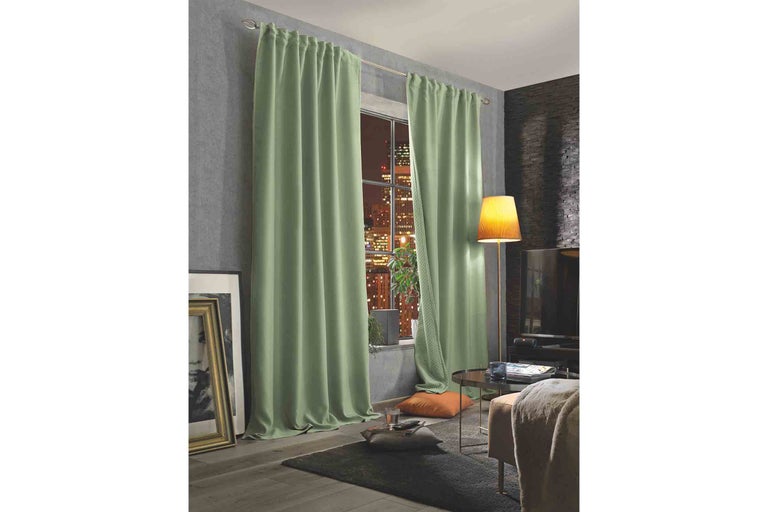Obývacia izba so zelenými závesmi zakrývajúcimi okno.