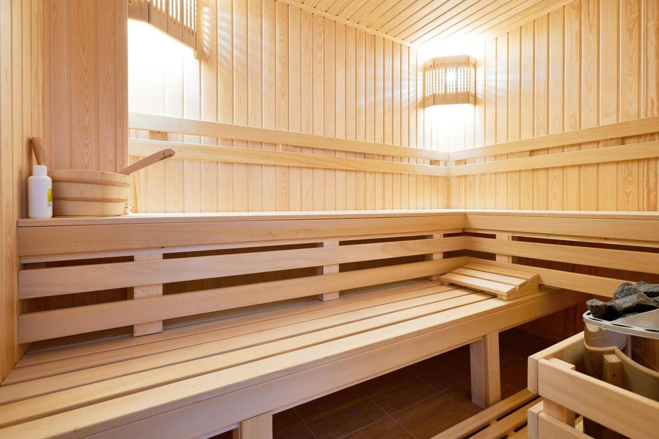 Drevená sauna s lavicami, vedrom a naberačkou