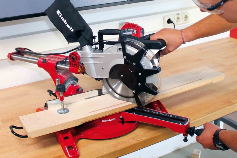Kapovacia a pokosová píla Einhell pri rezaní kusa dreva