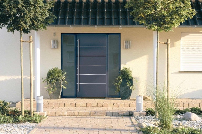 Fasáda domu s vchodovými dverami a bočnými sklenenými prvkami