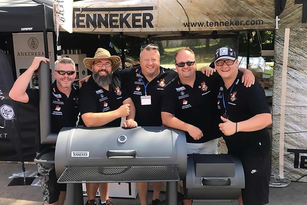 Skupina ľudí pózuje s grilom Tenneker