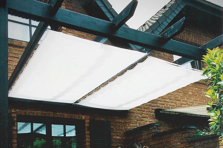 Pergola so slnečnou plachtou ako tieniaca ochrana na dome