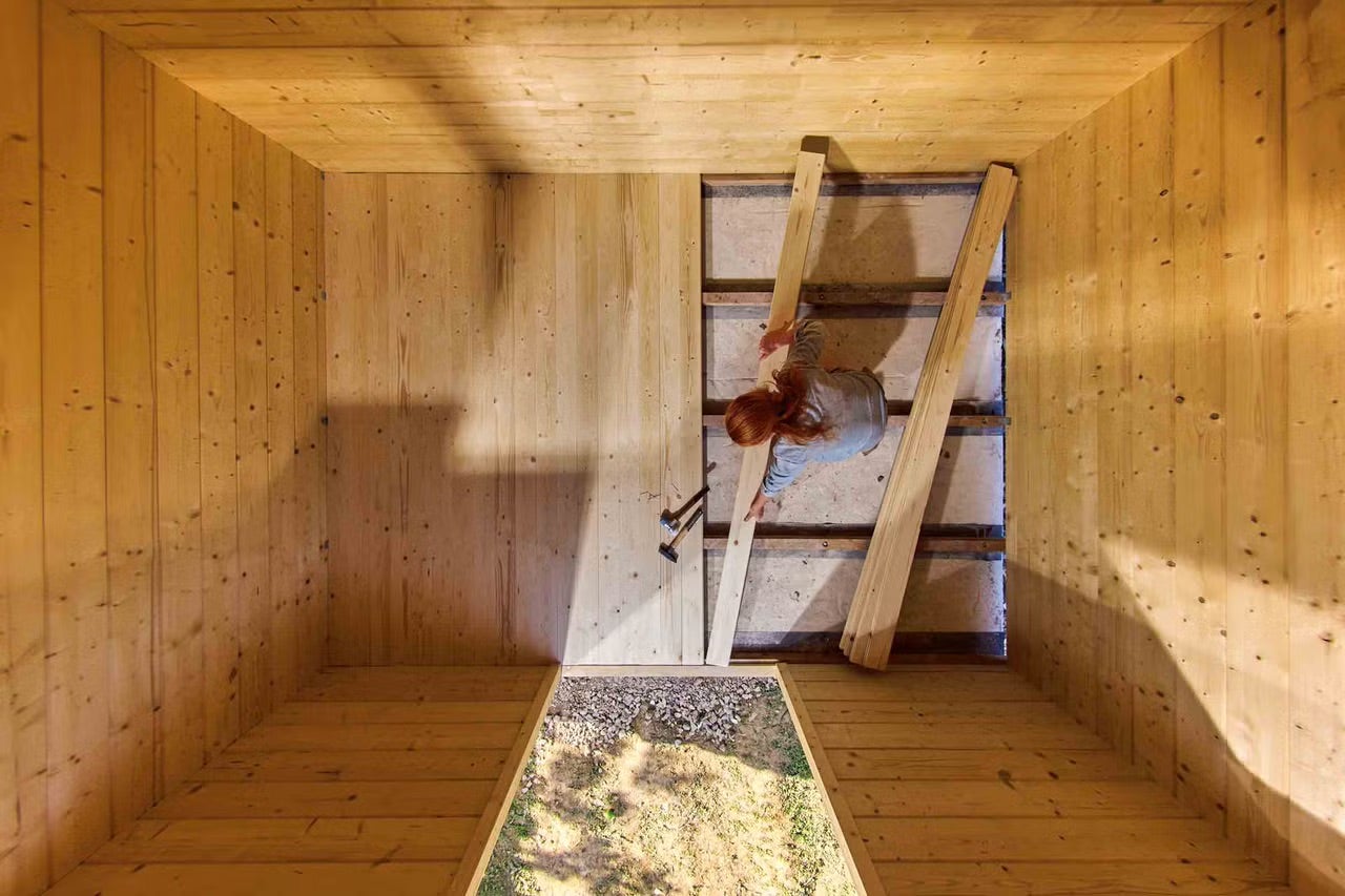 Drevená konštrukcia strechy s pracovníčkou inštalujúcou drevené dosky