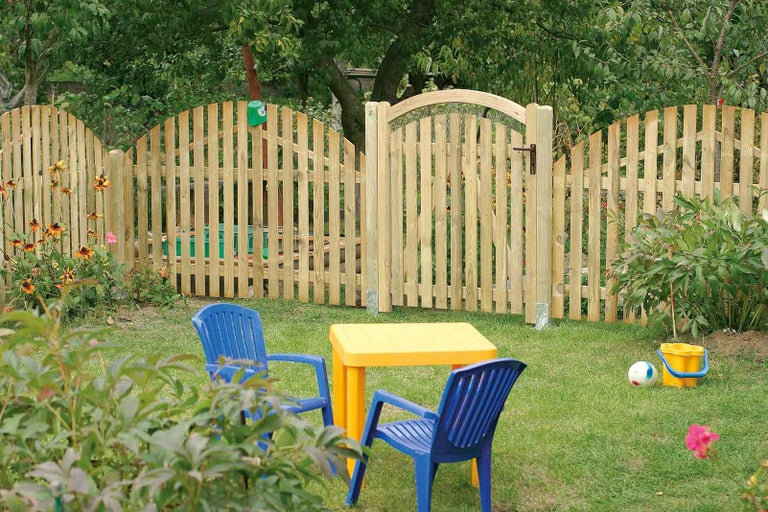 Drevený plot s bránkou, detský stôl a stoličky v záhrade