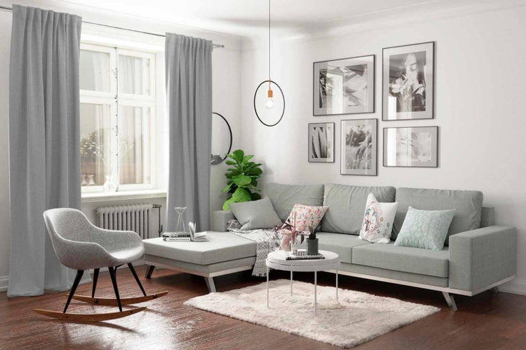 Svetlá obývacia izba so sivou pohovkou, závesmi, kobercom a dekoráciami