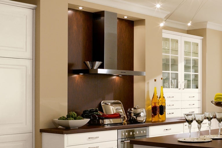 Kuchynská scéna s odsávačom pár, riadom a dekoráciami na pracovnej doske