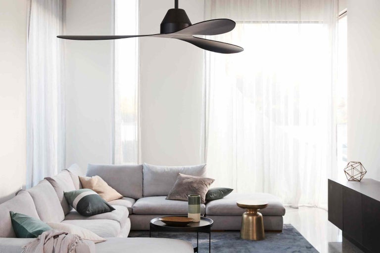 Obývacia izba so stropným ventilátorom, rohovou sedacou súpravou a moderným vybavením pre svetlé prostredie