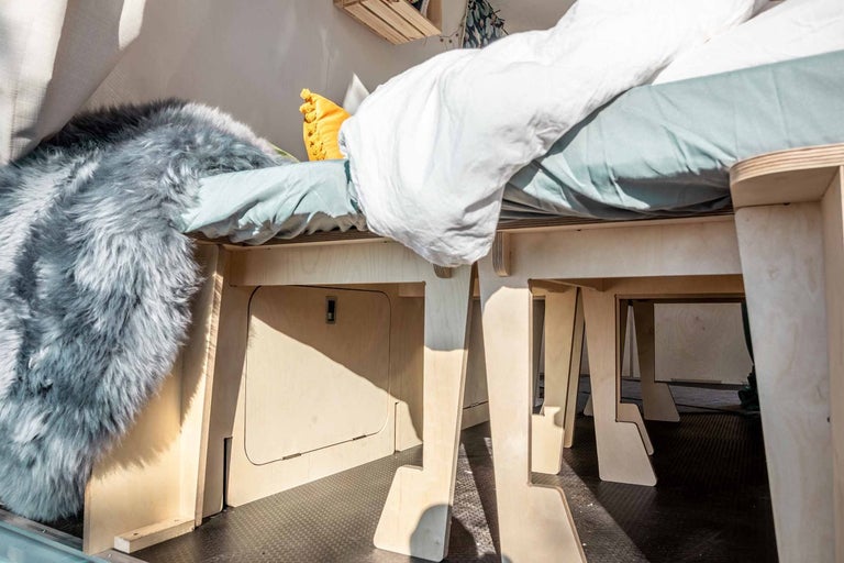 Interiér obytného voza s posteľou, úložným priestorom a ovčou kožou