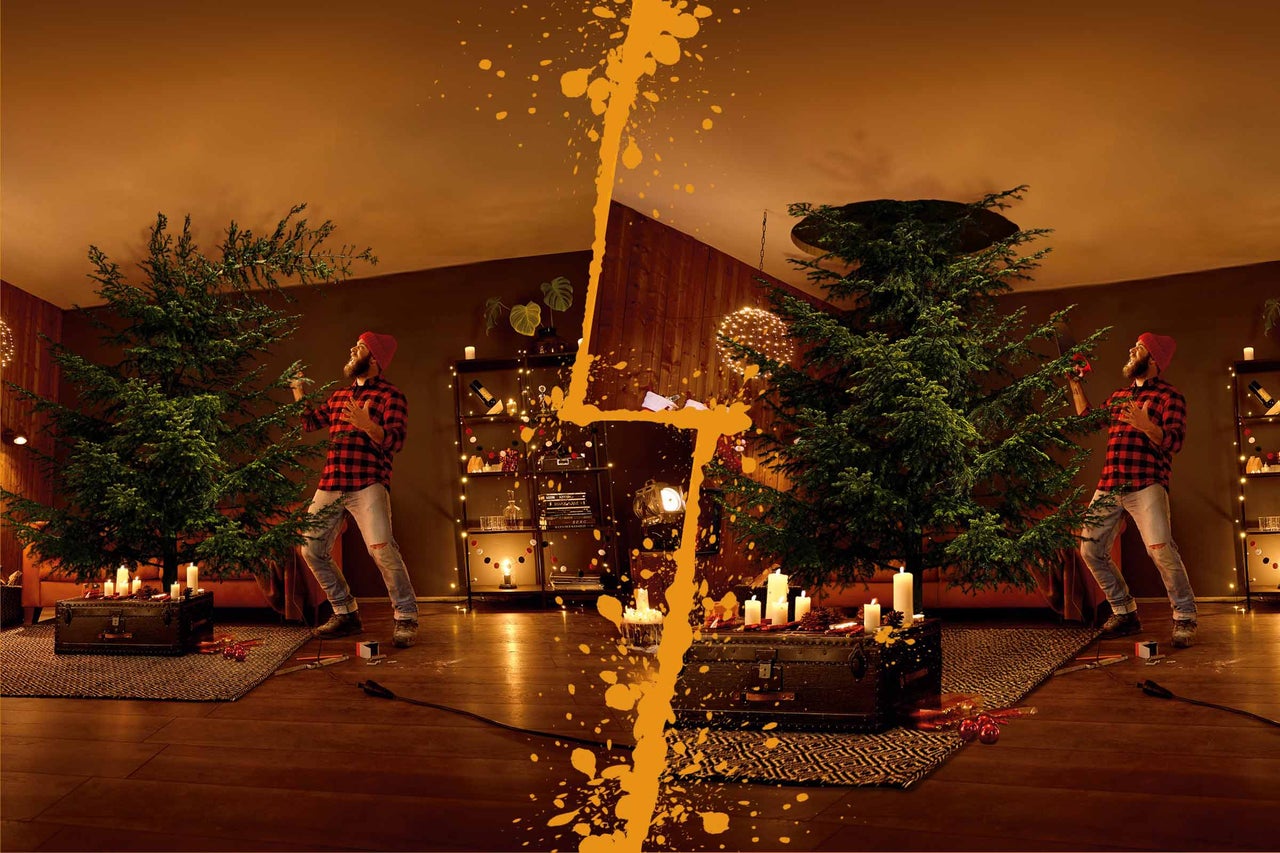 Ozdobený vianočný stromček v útulnej obývačke s mužom v pozadí