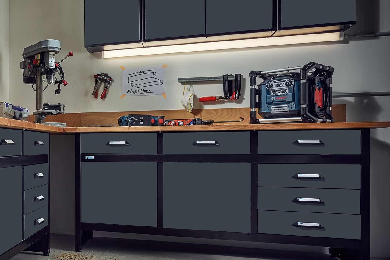 Pracovný stôl so zásuvkami, vŕtačka a staveniskové rádio v dielni