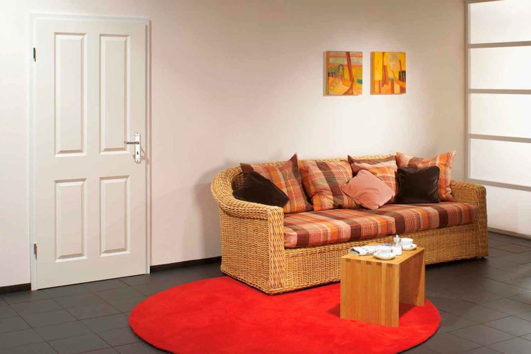 Obývacia izba s dverami, pohovkou, kobercom a príručným stolíkom