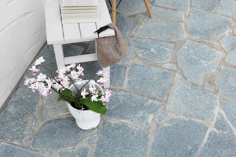 Prírodná kamenná dlažba s lavičkou a dekoráciou vo vonkajšom prostredí