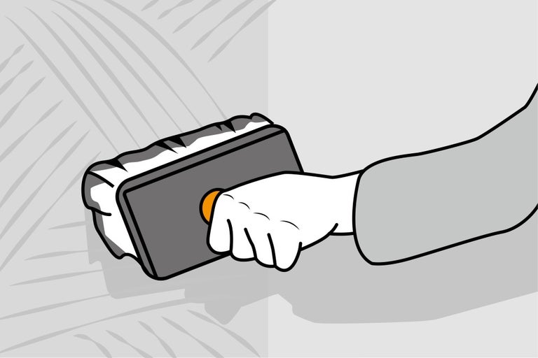 Ruka s hubkovým hladidlom pri škárovaní