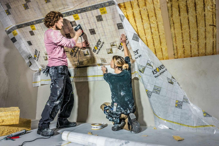 Dve osoby inštalujú parobrzdu Isover v podkroví.