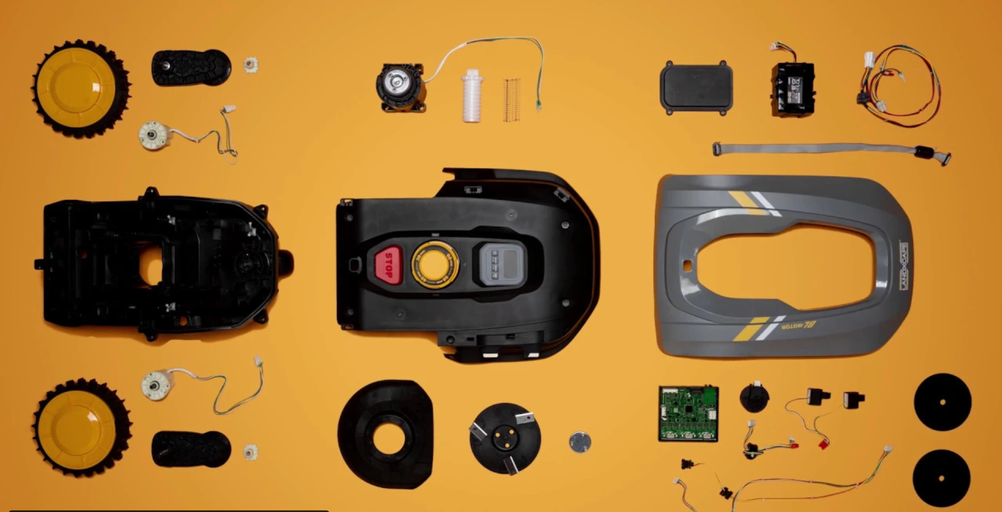 Rozkreslený nákres robotickej kosačky s rôznymi komponentmi, ako sú kolesá, kryt, elektronika a motory