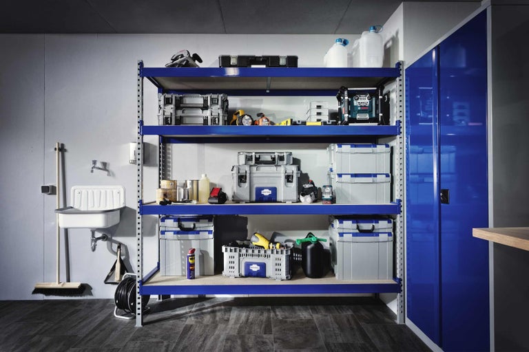 Dielňa s modrým regálom plným boxov na náradie a náradia vedľa umývadla
