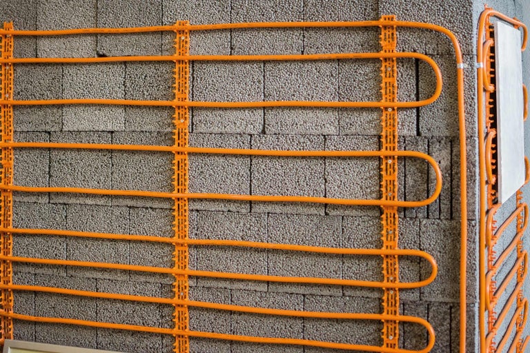 Nástenný vykurovací systém s upevňovacími lištami pred stenou