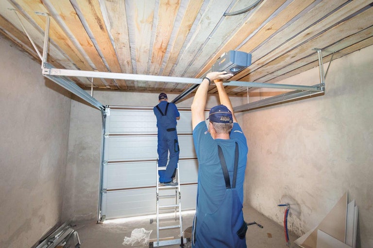 Montáž pohonu garážových dverí remeselníkmi v garáži