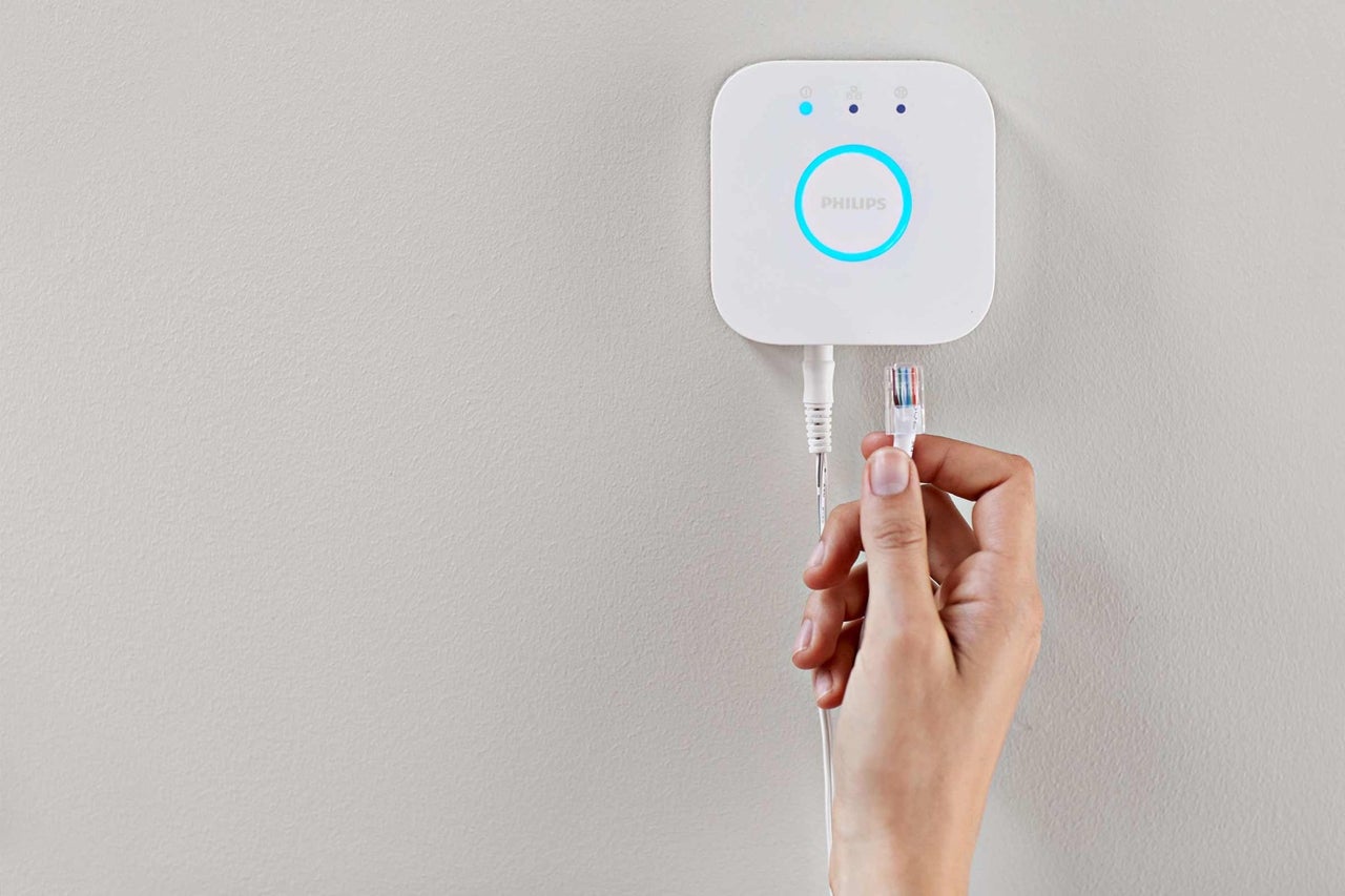 Philips Hue Bridge s ethernetovým káblom držaným rukou