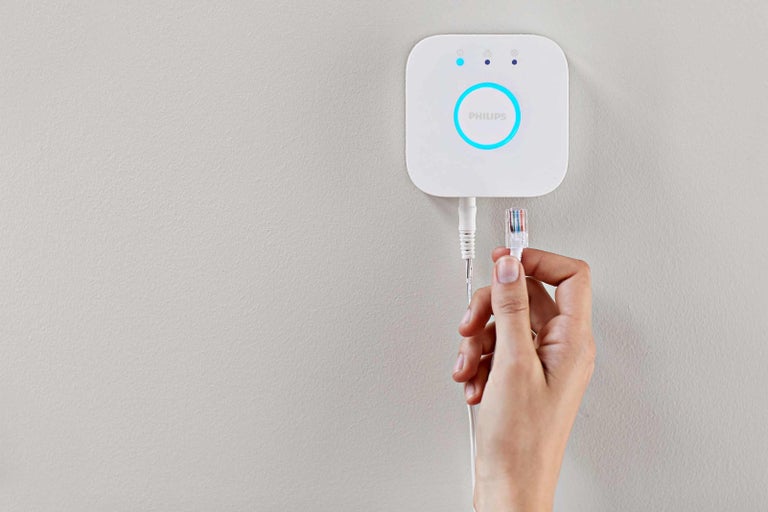 Philips Hue Bridge s ethernetovým káblom držaným rukou