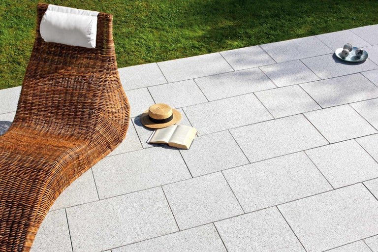 Scéna s ležadlom, knihou a kamennými dlaždicami pre vonkajšie použitie