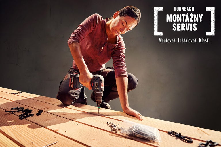 Žena pracuje s akumulátorovým skrutkovačom na drevenej terase. Montážny servis Hornbach.