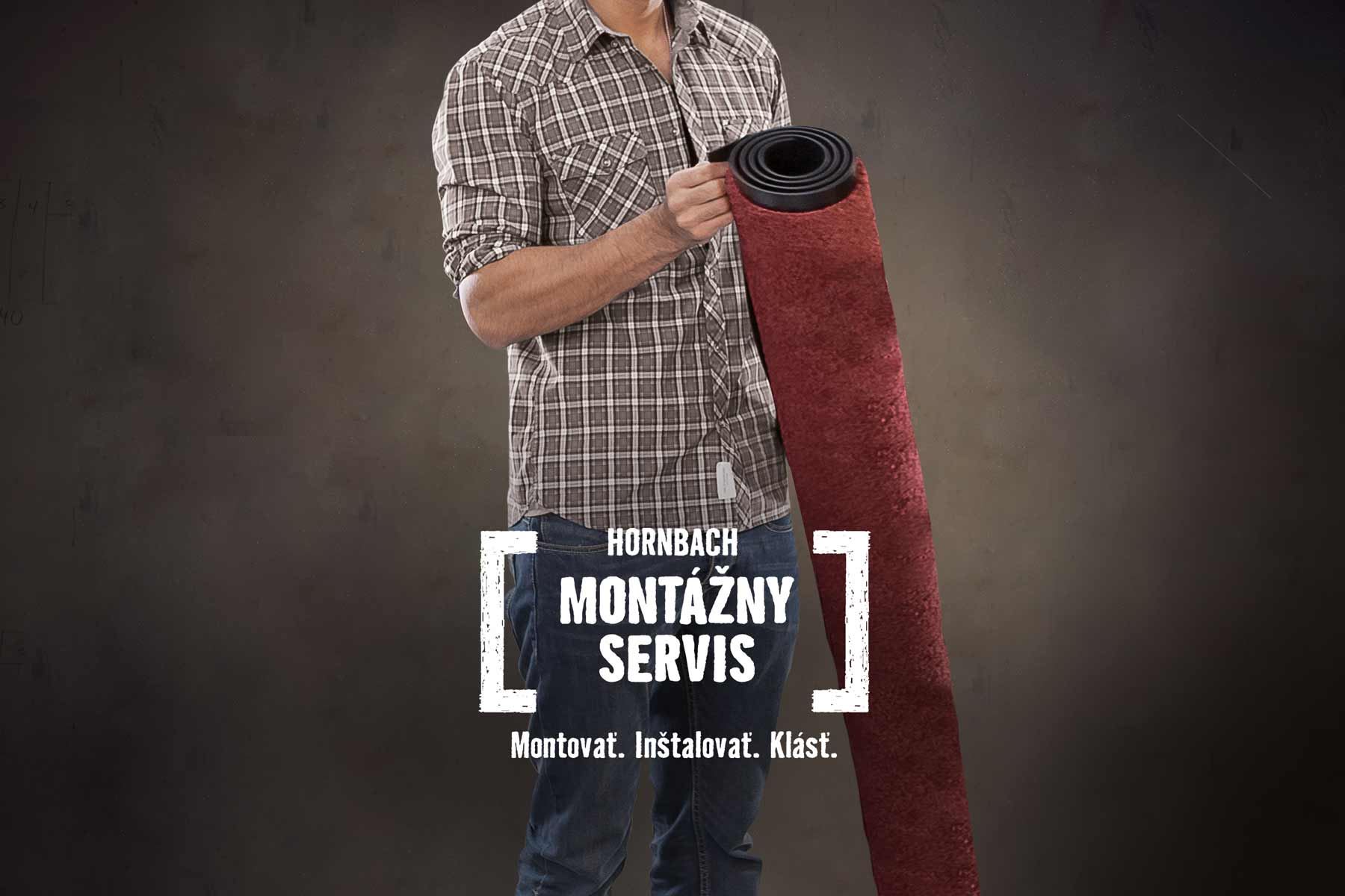 Muž drží zrolovanú rohožku. Montážny servis Hornbach.