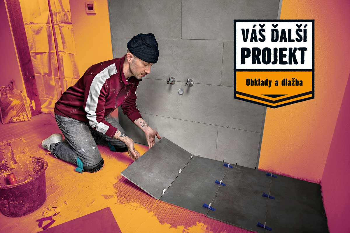 Muž pokladá obklady v kúpeľni; obkladačské práce