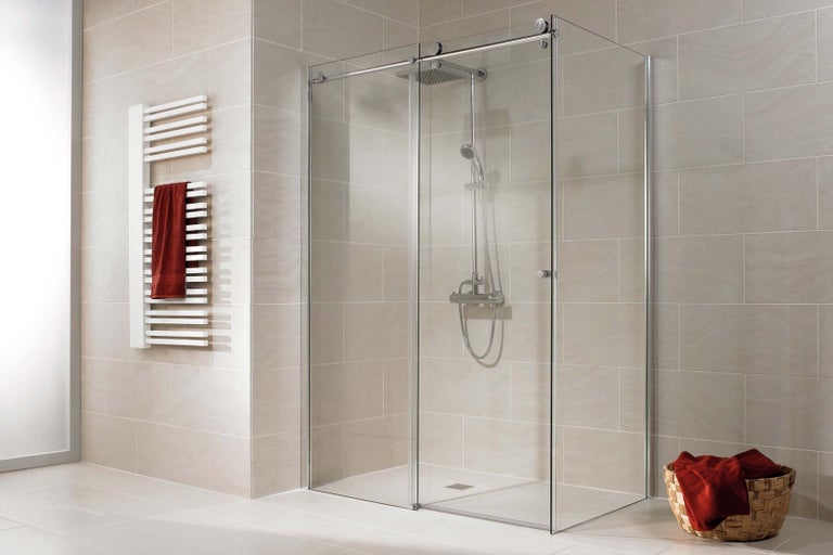 Svetlá kúpeľňa so skleneným sprchovacím kútom, ohrievačom uterákov a prúteným košom