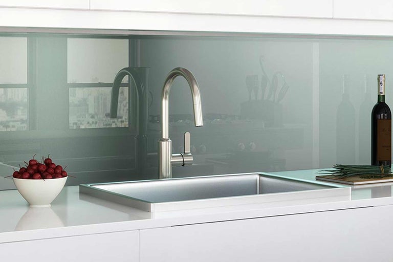 Kuchynská scéna s drezom, batériou a dekoratívnymi prvkami na bielej pracovnej doske