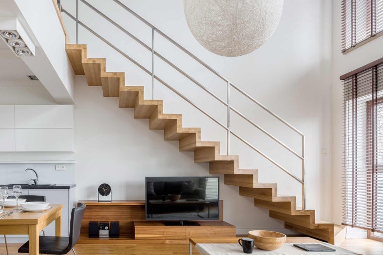 Svetlá obývacia izba s dreveným schodiskom a nerezovým zábradlím