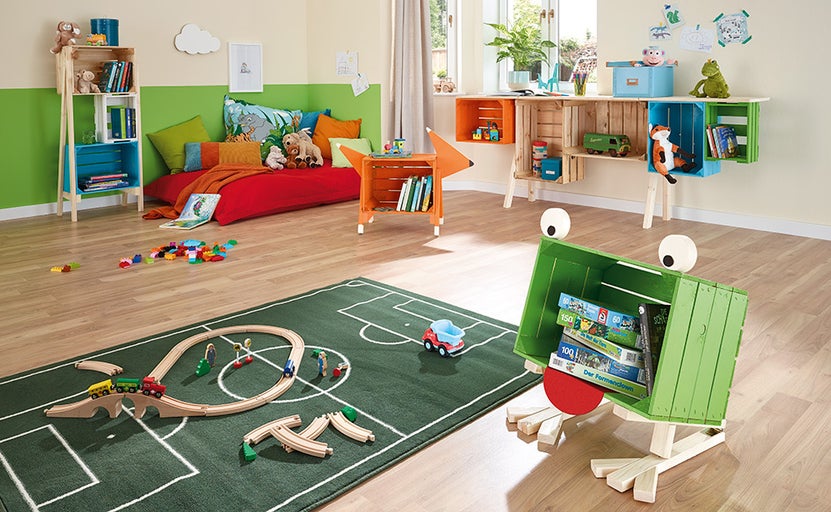 Detská izba s farebnými regálmi z drevených bední, hračkami a kobercom s futbalovým ihriskom