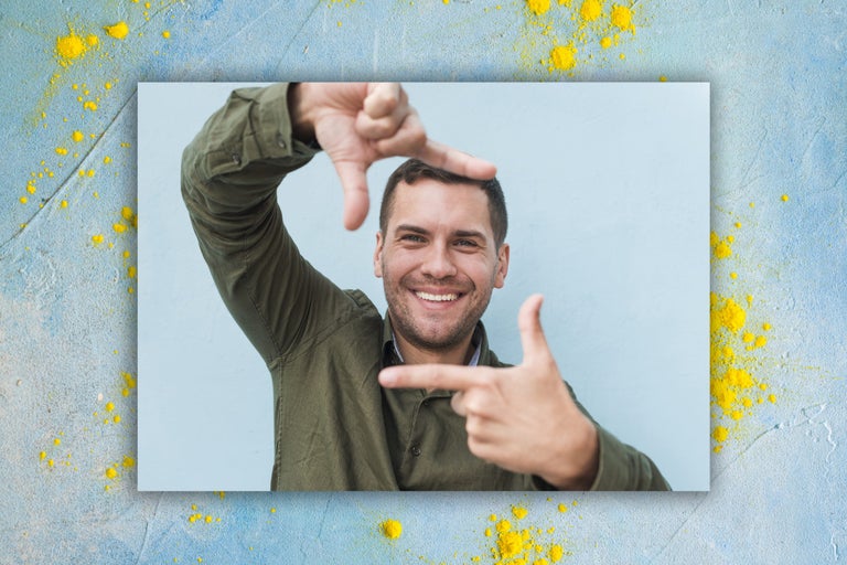 Usmievajúci sa muž tvorí rukami rám