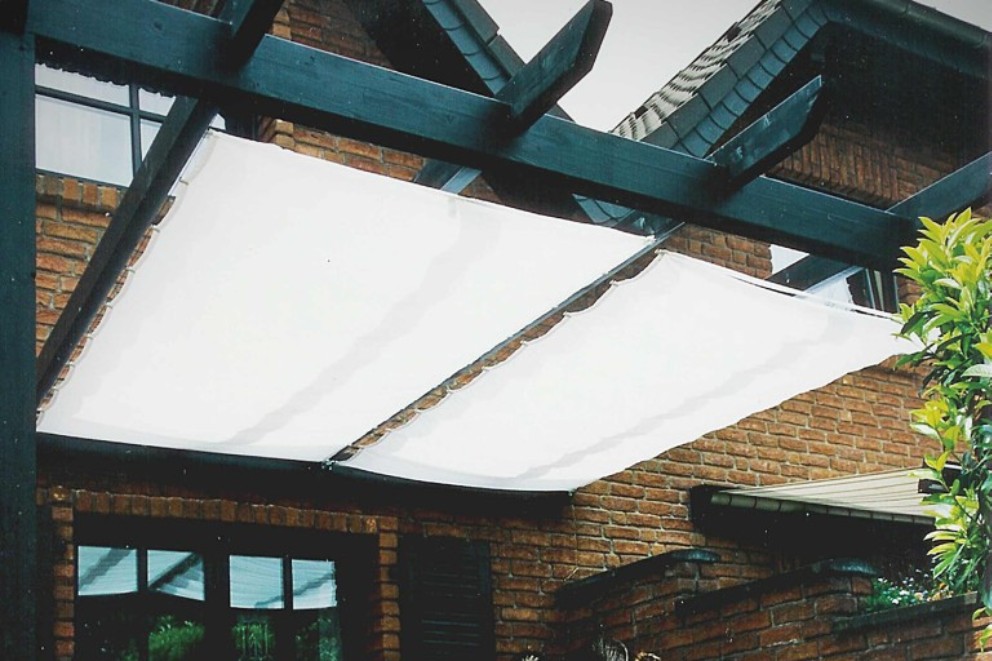 Pergola so slnečnou plachtou ako tieniaca ochrana na dome