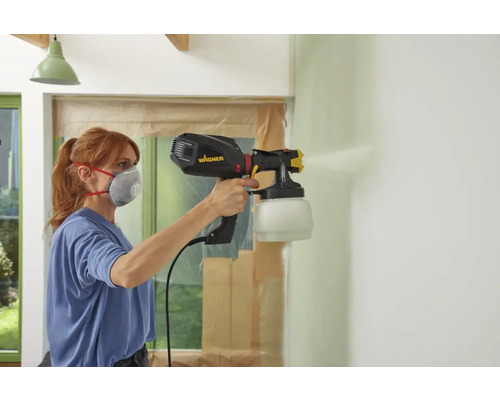 Žena natiera stenu striekacím systémom Wagner