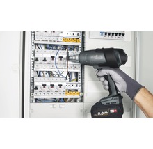 Elektrikár používa teplovzdušnú pištoľ Steinel Mobile Heat MH3 na rozvodnej skrini